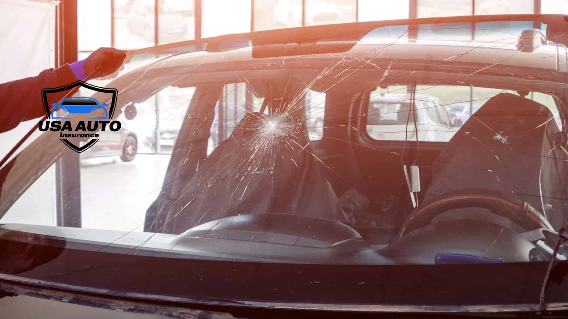 What Is Full Glass Coverage Auto Insurance A close-up view of a severely cracked car windshield being inspected for repair at an auto glass shop